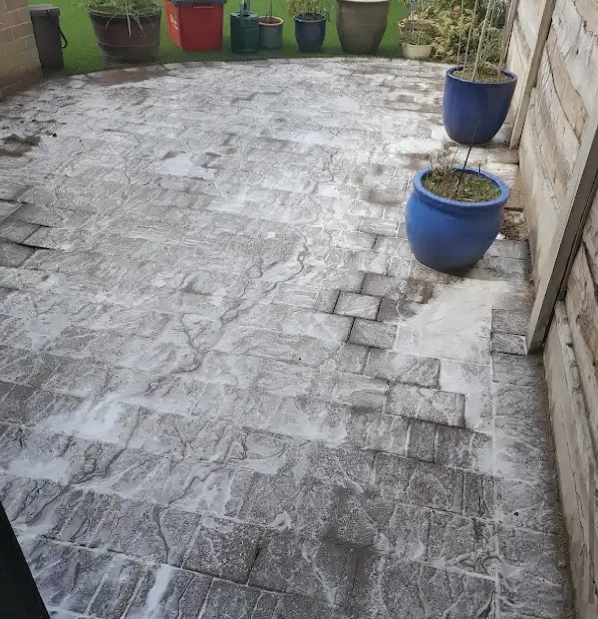 Cleaning treatment applied across a block-paved patio