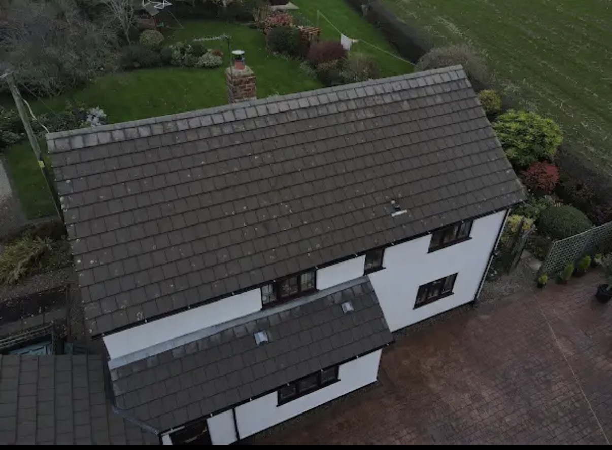 Side aerial view of a cleaned roof and surrounding gutters